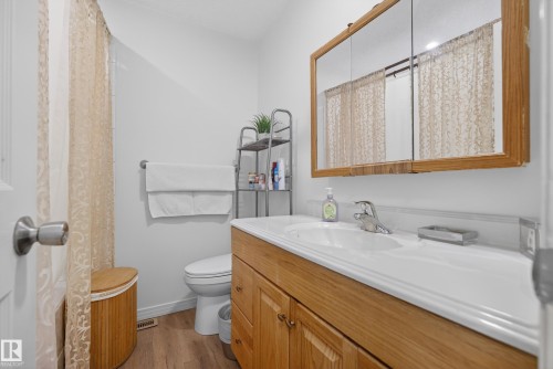 Bathroom with vanity, light wood-style flooring, and a shower with curtain - 17303 101 Street, Edmonton, AB - Indoor Photo Showing Bathroom