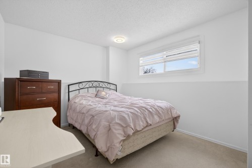 Carpeted bedroom with a textured ceiling and baseboards - 17303 101 Street, Edmonton, AB - Indoor Photo Showing Bedroom