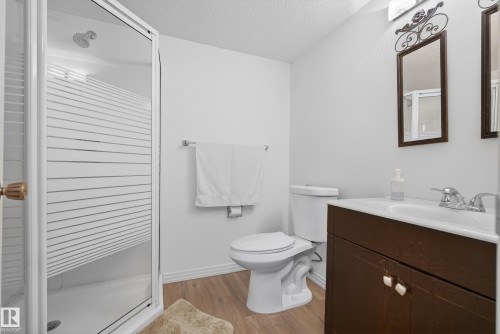 Full bath with a stall shower, vanity, light wood finished floors, and a textured ceiling - 17303 101 Street, Edmonton, AB - Indoor Photo Showing Bathroom