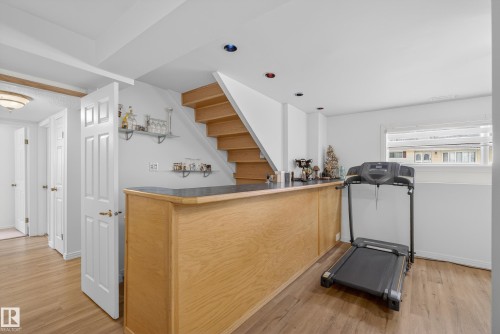 Exercise area featuring light wood-type flooring and a dry bar - 17303 101 Street, Edmonton, AB - Indoor Photo Showing Gym Room