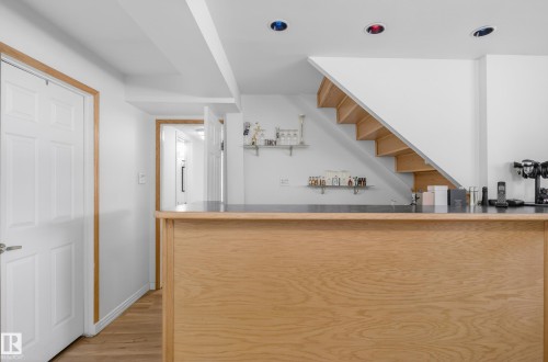 Indoor wet bar with open shelves, light wood-style flooring, and dark countertops - 17303 101 Street, Edmonton, AB - Indoor Photo Showing Other Room