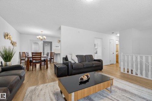 Living area featuring hanging lights, light wood-type flooring, and a textured ceiling - 17303 101 Street, Edmonton, AB - Indoor Photo Showing Living Room