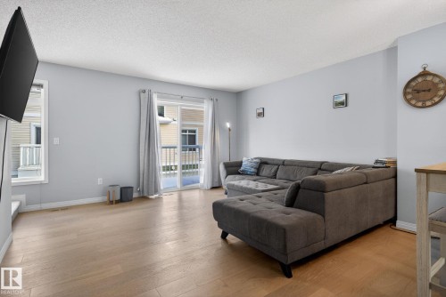 Living room featuring light wood-style floors and a textured ceiling - 60 1804 70 Street, Edmonton, AB - Indoor Photo Showing Living Room