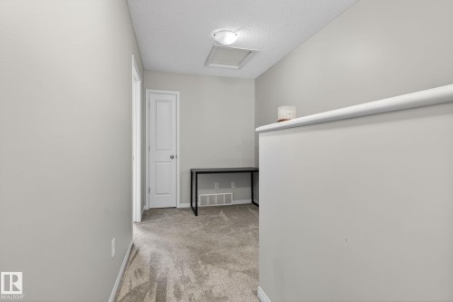 Hallway with light colored carpet and a textured ceiling - 60 1804 70 Street, Edmonton, AB - Indoor Photo Showing Other Room