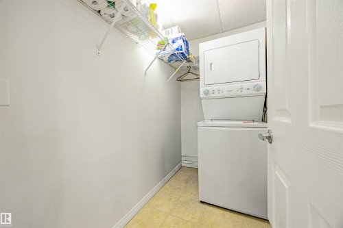 Laundry room with stacked washing machine and dryer and baseboards - 132 6220 134 Avenue, Edmonton, AB - Indoor Photo Showing Laundry Room