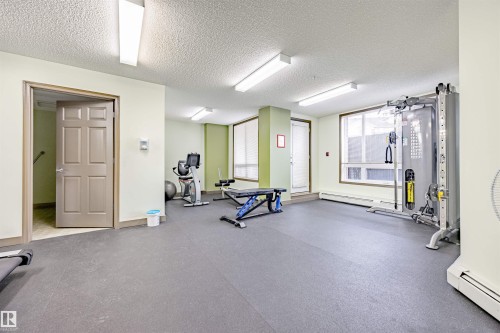 Workout area featuring baseboard heating and a textured ceiling - 132 6220 134 Avenue, Edmonton, AB - Indoor Photo Showing Gym Room
