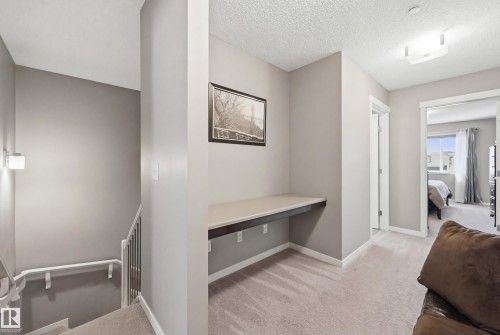 Hallway with light carpet, an office area, a textured ceiling, and an upstairs landing - 2031 Westerra Loop, Stony Plain, AB - Indoor Photo Showing Other Room