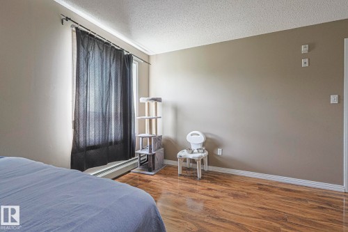 Bedroom with a textured ceiling and dark wood-type flooring - 314 5340 199 Street, Edmonton, AB - Indoor Photo Showing Bedroom