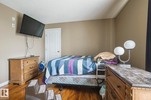 Bedroom with dark wood-style flooring and a textured ceiling - 314 5340 199 Street, Edmonton, AB - Indoor Photo Showing Bedroom