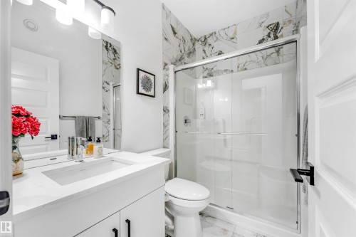 Full bathroom featuring vanity, a stall shower, and light marble finish floors - 2629 15A Avenue, Edmonton, AB - Indoor Photo Showing Bathroom