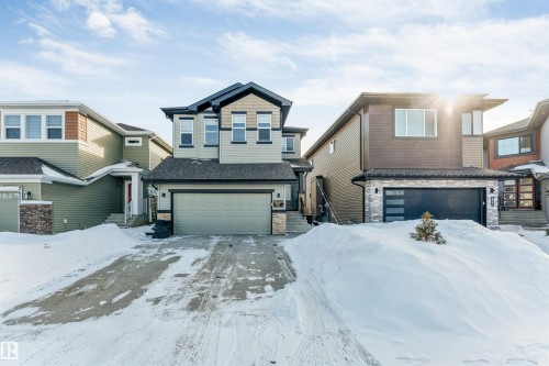 View of front of house featuring stone siding, an attached garage, and roof with shingles - 2629 15A Avenue, Edmonton, AB - Outdoor With Facade