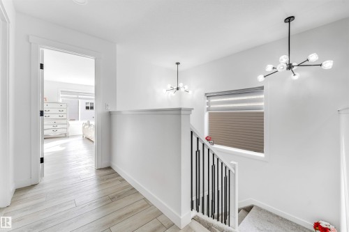 Hall with a chandelier, an upstairs landing, and light wood-type flooring - 2629 15A Avenue, Edmonton, AB - Indoor Photo Showing Other Room