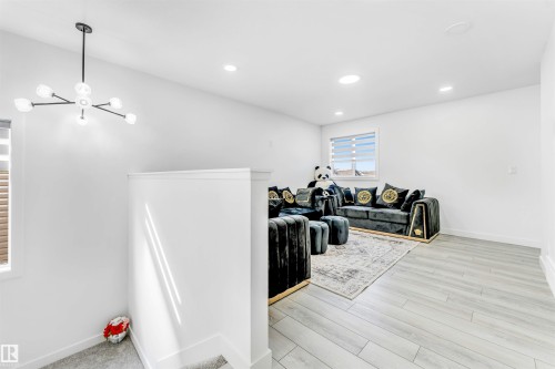 Living area with light wood-style floors and a chandelier - 2629 15A Avenue, Edmonton, AB - Indoor Photo Showing Other Room