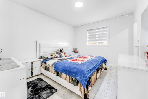 Bedroom featuring washer / clothes dryer and light wood-style flooring - 2629 15A Avenue, Edmonton, AB - Indoor Photo Showing Bedroom