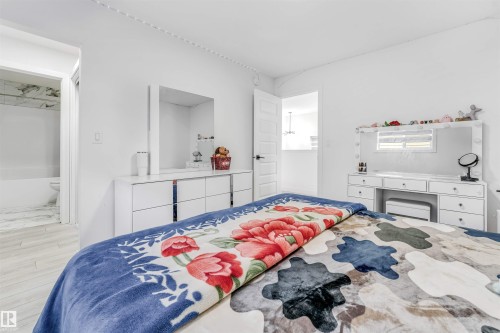 Bedroom featuring light wood finished floors and ensuite bath - 2629 15A Avenue, Edmonton, AB - Indoor Photo Showing Bedroom