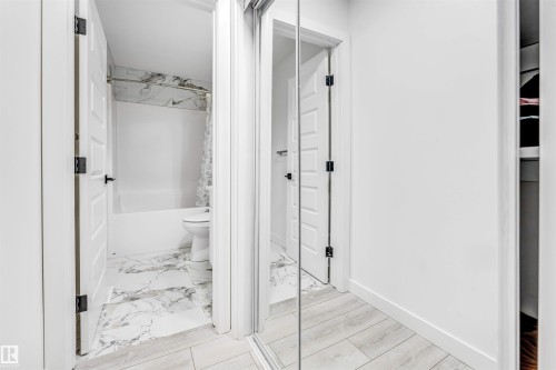 Bathroom featuring shower / tub combo with curtain and light marble finish floors - 2629 15A Avenue, Edmonton, AB - Indoor