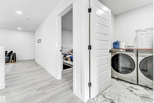 Laundry area with washer and dryer, recessed lighting, and light wood-style flooring - 2629 15A Avenue, Edmonton, AB - Indoor Photo Showing Laundry Room
