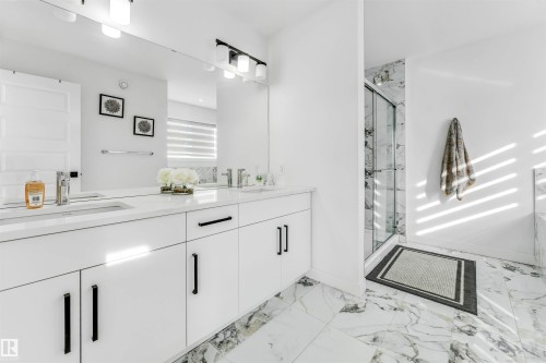 Bathroom featuring double vanity, a marble finish shower, and light marble finish flooring - 2629 15A Avenue, Edmonton, AB - Indoor Photo Showing Bathroom