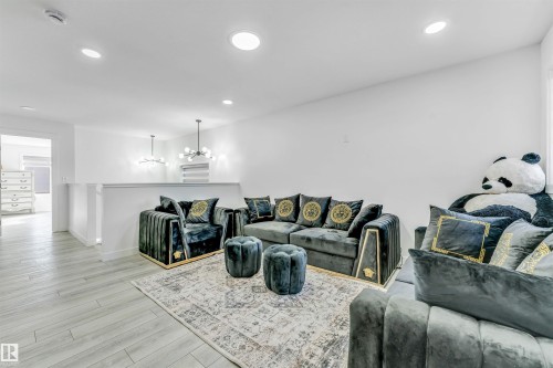 Living area with a chandelier and light wood-style flooring - 2629 15A Avenue, Edmonton, AB - Indoor Photo Showing Living Room