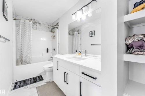 Full bathroom featuring vanity, shower / tub combo, and light marble finish floors - 2629 15A Avenue, Edmonton, AB - Indoor Photo Showing Bathroom