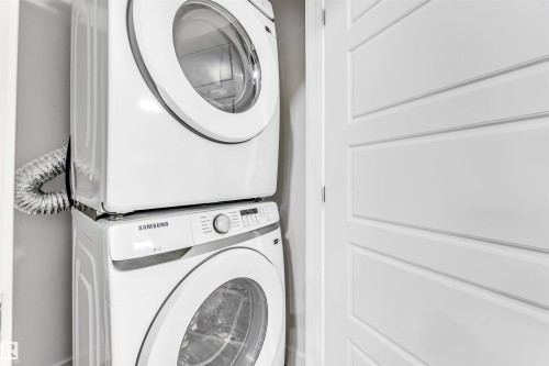 Laundry area with stacked washing machine and dryer - 2629 15A Avenue, Edmonton, AB - Indoor Photo Showing Laundry Room