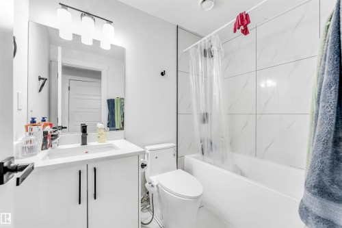 Bathroom featuring vanity and shower / bath combo with shower curtain - 2629 15A Avenue, Edmonton, AB - Indoor Photo Showing Bathroom