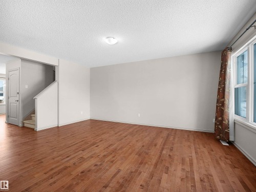 Unfurnished room featuring plenty of natural light, a textured ceiling, and hardwood / wood-style flooring - 1708 62 Street, Edmonton, AB - Indoor Photo Showing Other Room