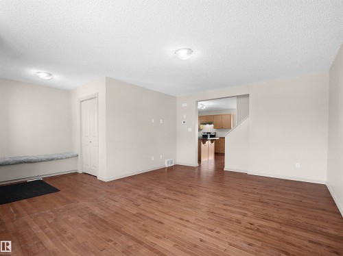 Unfurnished room with a textured ceiling and dark wood-style flooring - 1708 62 Street, Edmonton, AB - Indoor Photo Showing Other Room