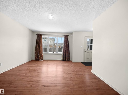 Unfurnished room featuring dark wood finished floors and a textured ceiling - 1708 62 Street, Edmonton, AB - Indoor Photo Showing Other Room
