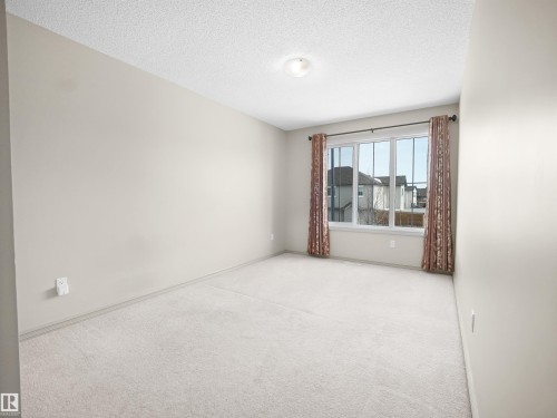 Carpeted empty room featuring a textured ceiling - 1708 62 Street, Edmonton, AB - Indoor Photo Showing Other Room