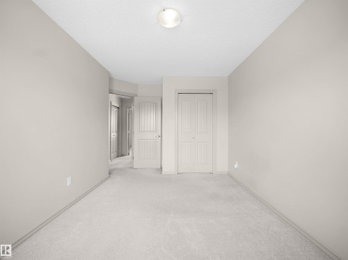 Unfurnished bedroom with light colored carpet, a closet, and a textured ceiling - 1708 62 Street, Edmonton, AB - Indoor Photo Showing Other Room