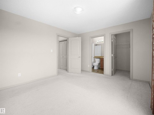 Unfurnished bedroom with a spacious closet, light colored carpet, and ensuite bathroom - 1708 62 Street, Edmonton, AB - Indoor Photo Showing Other Room