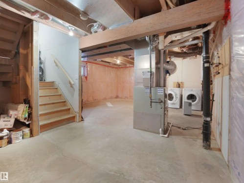 Unfinished basement featuring stairway and heating unit - 1708 62 Street, Edmonton, AB - Indoor Photo Showing Basement
