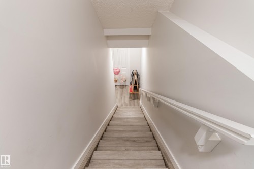 Stairway featuring a textured ceiling and wood finished floors - 304 36 Avenue, Edmonton, AB - Indoor Photo Showing Other Room