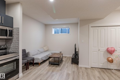 Living area with light wood-type flooring and a textured ceiling - 304 36 Avenue, Edmonton, AB - Indoor