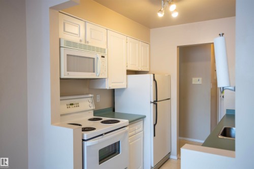 Kitchen with white appliances and white cabinets - 207 11465 41 Avenue, Edmonton, AB - Indoor Photo Showing Kitchen