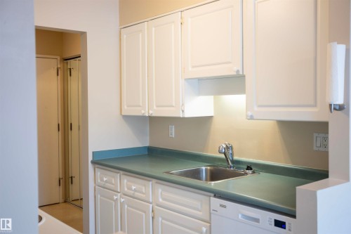 Kitchen featuring white cabinetry, white dishwasher, and dark countertops - 207 11465 41 Avenue, Edmonton, AB - Indoor Photo Showing Kitchen