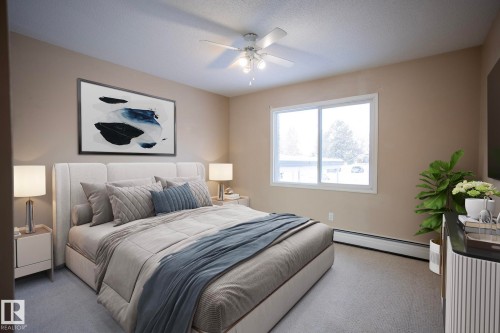 Bedroom featuring baseboard heating, a ceiling fan, carpet floors, and a textured ceiling - 207 11465 41 Avenue, Edmonton, AB - Indoor Photo Showing Bedroom