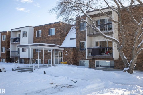 Snow covered rear of property featuring a balcony and brick siding - 207 11465 41 Avenue, Edmonton, AB - Outdoor With Facade