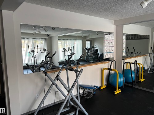 Dedicated fitness room featuring wall-to-wall mirrors and track lighting - 207 11465 41 Avenue, Edmonton, AB - Indoor Photo Showing Gym Room