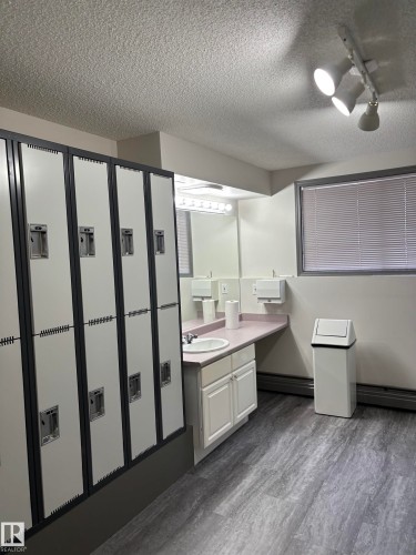 Integrated locker storage with gray and white finishes - 207 11465 41 Avenue, Edmonton, AB - Indoor Photo Showing Bathroom