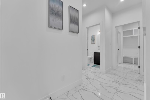 Hall with recessed lighting and light marble finish floors - 16812 48 Street Nw, Edmonton, AB - Indoor Photo Showing Other Room