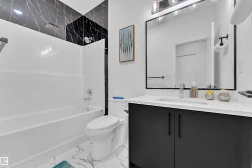 Full bath with vanity, bathtub / shower combination, and light marble finish floors - 16812 48 Street Nw, Edmonton, AB - Indoor Photo Showing Bathroom