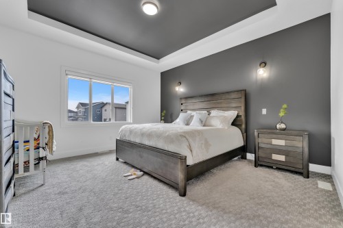 Bedroom with a tray ceiling and light colored carpet - 16812 48 Street Nw, Edmonton, AB - Indoor Photo Showing Bedroom