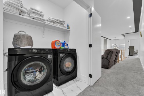 Laundry area with recessed lighting, washer and clothes dryer, and light colored carpet - 16812 48 Street Nw, Edmonton, AB - Indoor Photo Showing Laundry Room