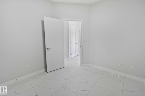 Unfurnished room featuring baseboards and light marble finish floors - 3524 41 Ave, Beaumont, AB - Indoor Photo Showing Other Room