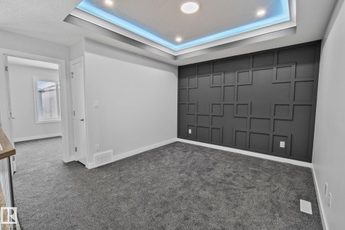 Empty room with dark carpet and a raised ceiling - 3524 41 Ave, Beaumont, AB - Indoor Photo Showing Other Room