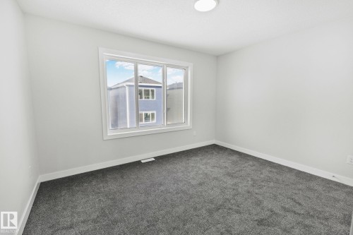 Empty room with baseboards and dark carpet - 3524 41 Ave, Beaumont, AB - Indoor Photo Showing Other Room