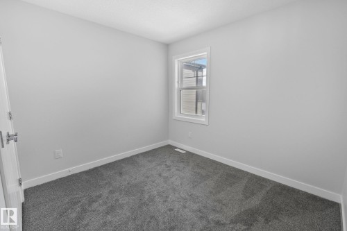 Spare room featuring dark carpet and a textured ceiling - 3524 41 Ave, Beaumont, AB - Indoor Photo Showing Other Room