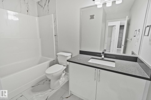 Full bath with vanity, tub / shower combination, and light marble finish floors - 3524 41 Ave, Beaumont, AB - Indoor Photo Showing Bathroom